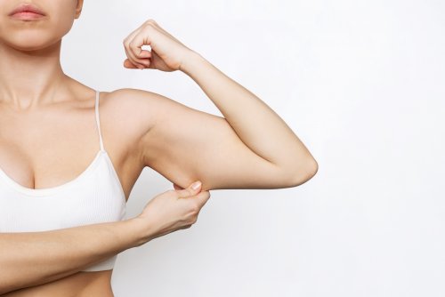 cropped-shot-young-woman-grabbing-skin-her-upper-arm-with-excess-fat-white-background.jpg
